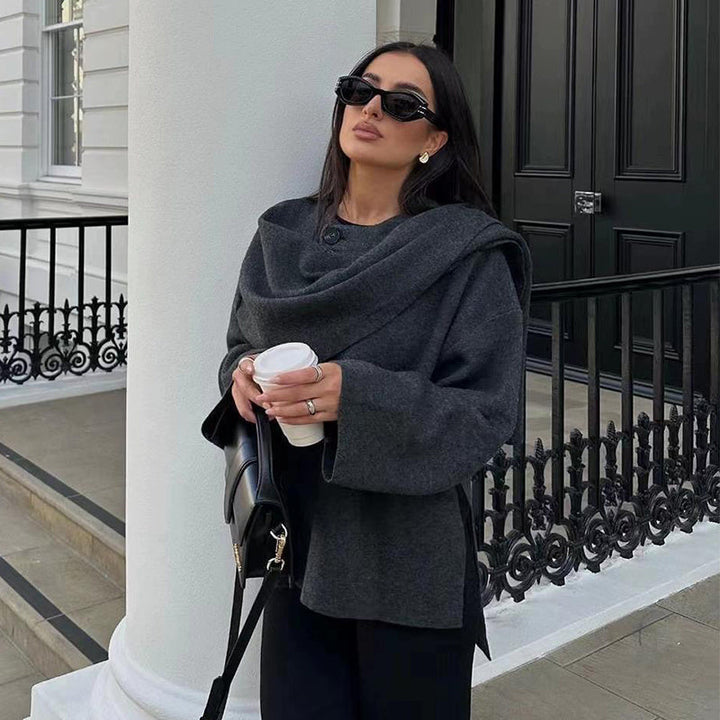 Woman wearing dark grey cosy wool coat outdoors holding coffee
