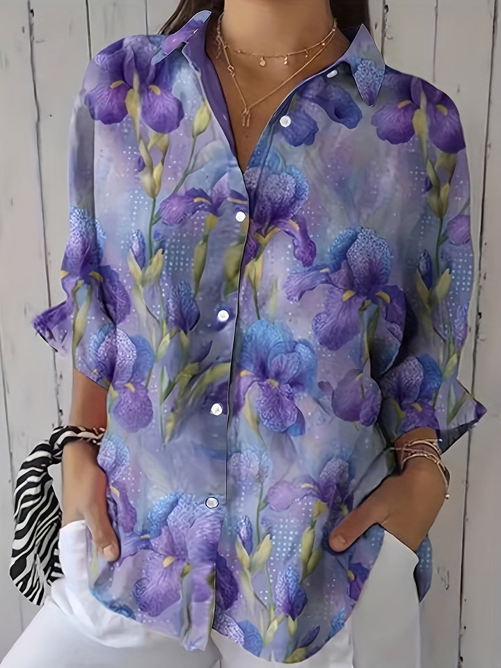 Woman wearing a purple floral button-up blouse with white trousers