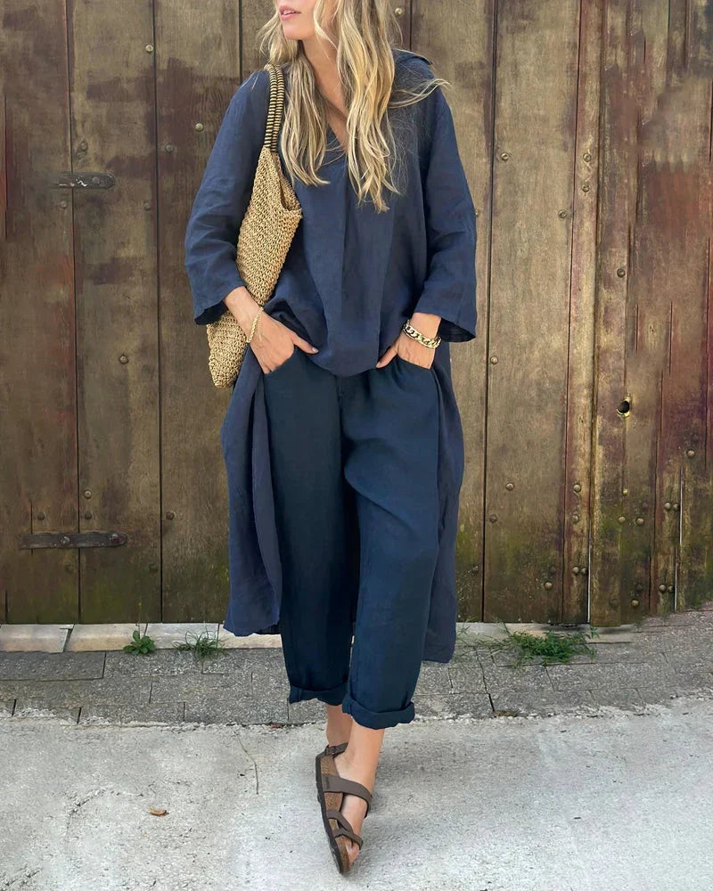 Woman wearing a dark blue summer two-piece coordinated outfit with sandals and a straw bag