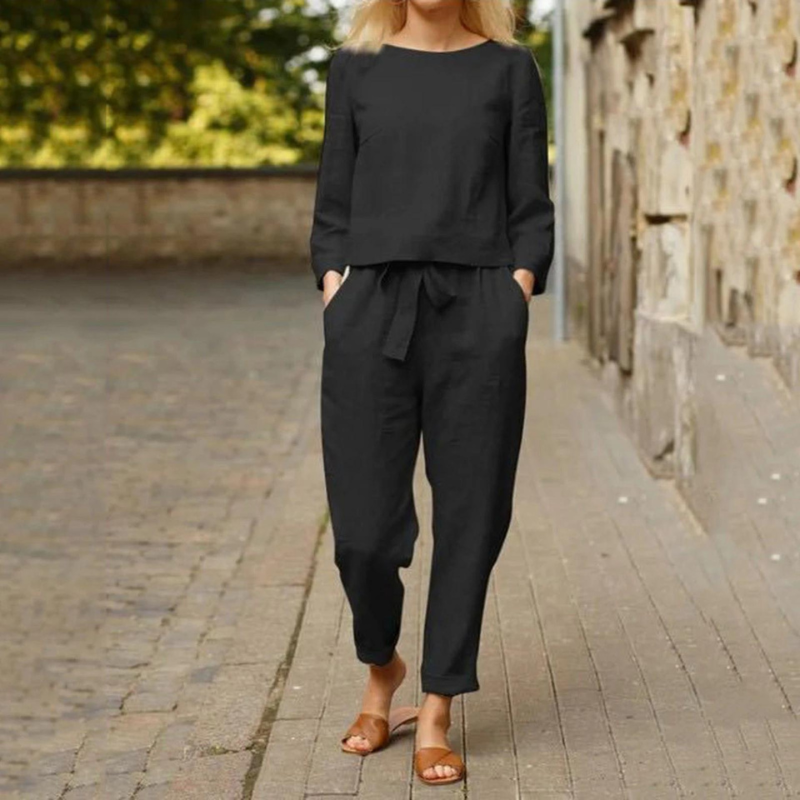 Woman wearing a black long-sleeve blouse and matching pants set outdoors
