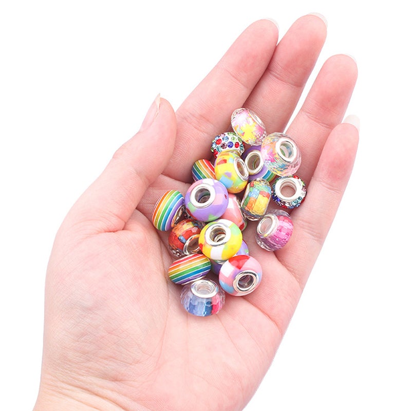 Hand holding various vibrant beads and charms for jewelry making