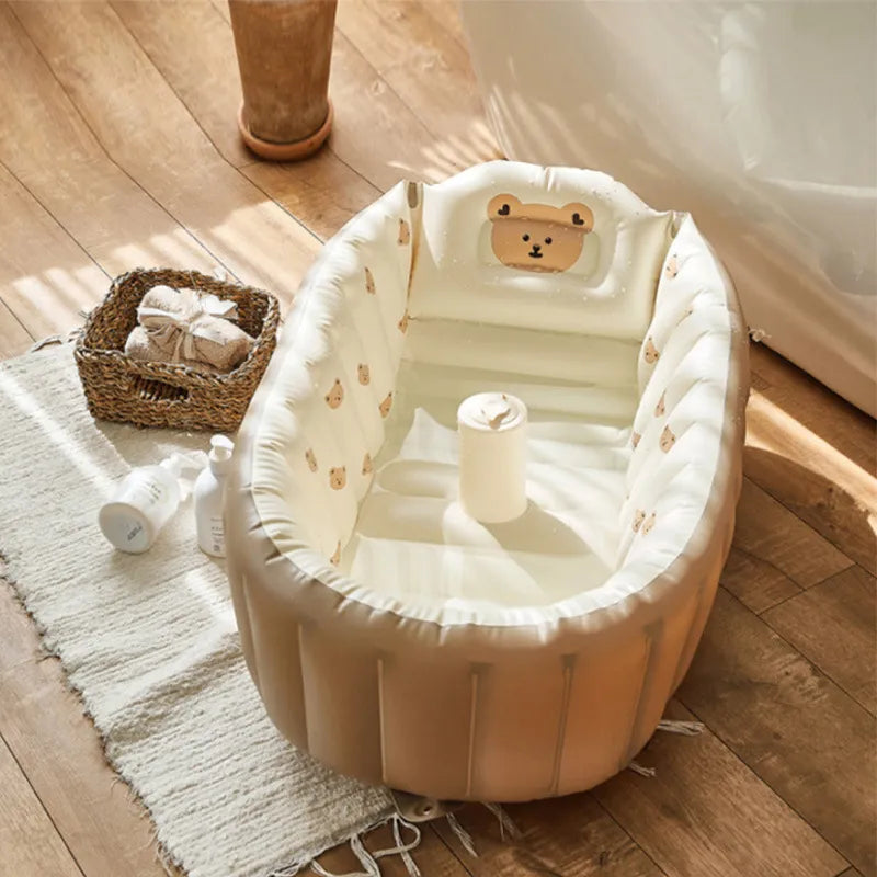 Inflatable baby bath tub featuring a cute bear print set up on a wooden floor