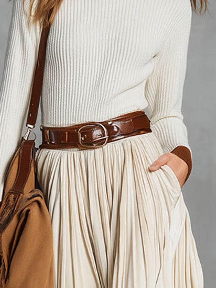 Close-up of the waistband and pocket details on a beige midi skirt