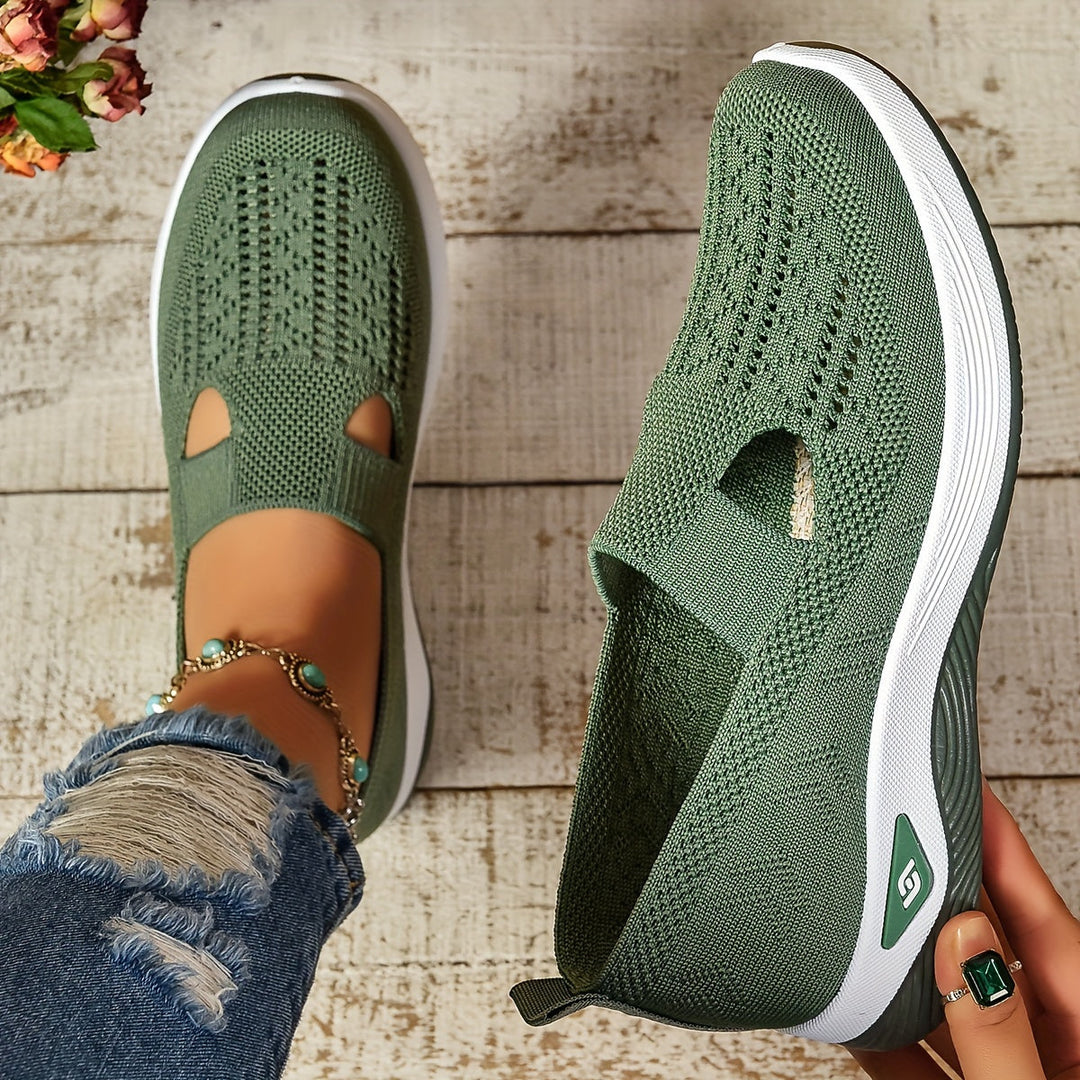 Women's green slip-on orthopedic walking shoes being held up