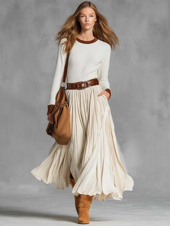 Full view of a model in a beige midi skirt and knitted top
