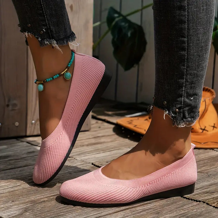 Women's light pink comfort walking shoes worn outdoors on a wooden deck.