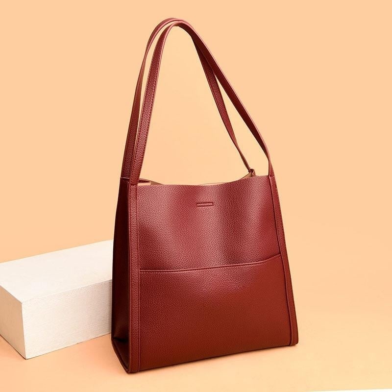 Women's luxury tote bag in classic black showing front design and handles
