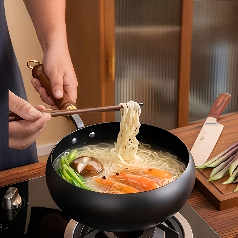 Chef cooking delicious noodles in a black cast iron pan with wooden handle