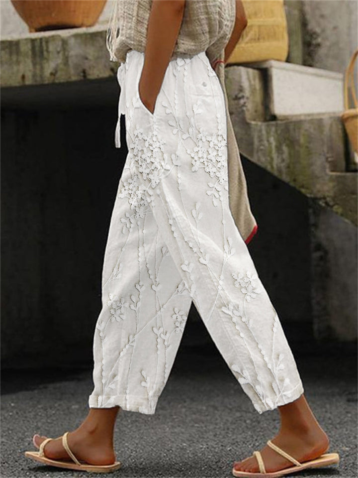 Woman wearing white trendy printed trousers paired with sandals