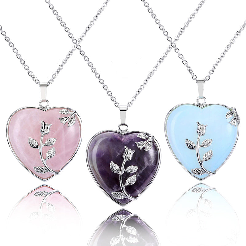 Three heart-shaped gemstone necklaces in Rose Quartz, Amethyst, and Opal styles displayed together.