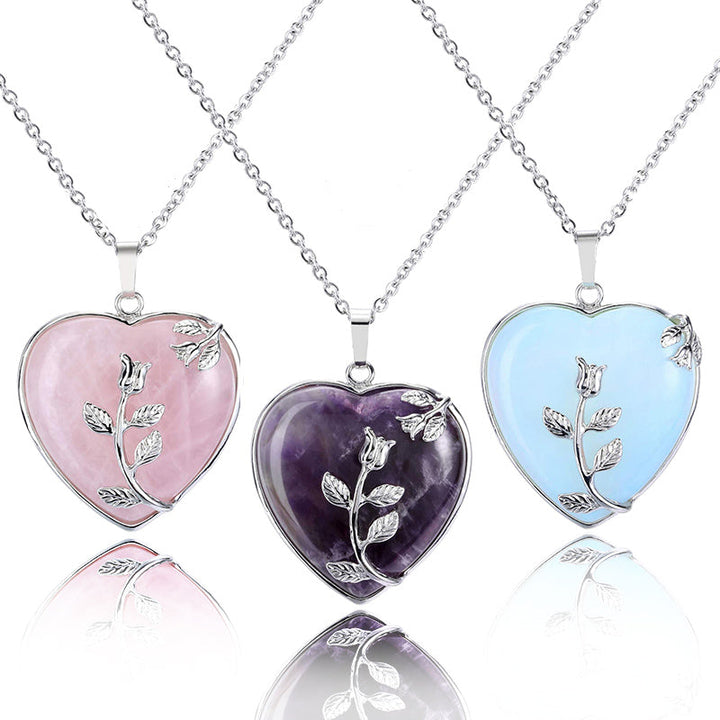 Three heart-shaped gemstone necklaces in Rose Quartz, Amethyst, and Opal styles displayed together.