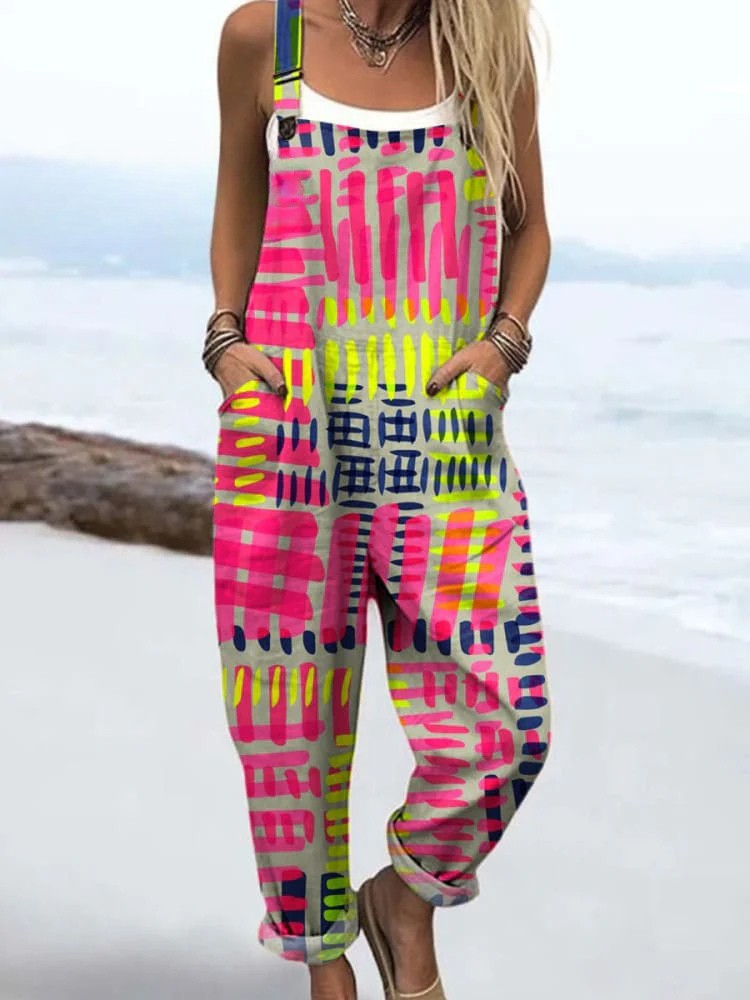 Woman wearing a colourful printed overall jumpsuit with straps on a beach background