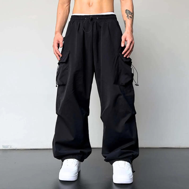 Unisex relaxed fit cargo joggers in black showing deep side utility pockets