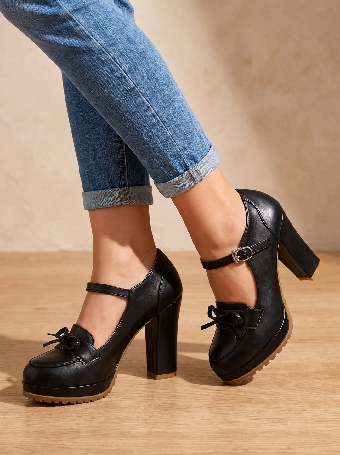 Model wearing black Mary Jane block heel pumps with bow paired with jeans