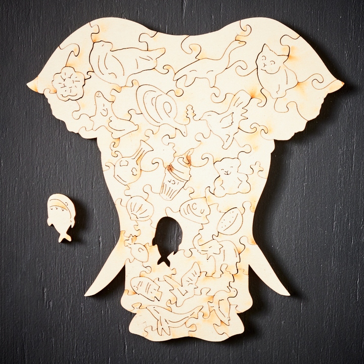 Unisex wooden animal jigsaw puzzle pieces spread out, showcasing intricate shapes and natural wood grain.