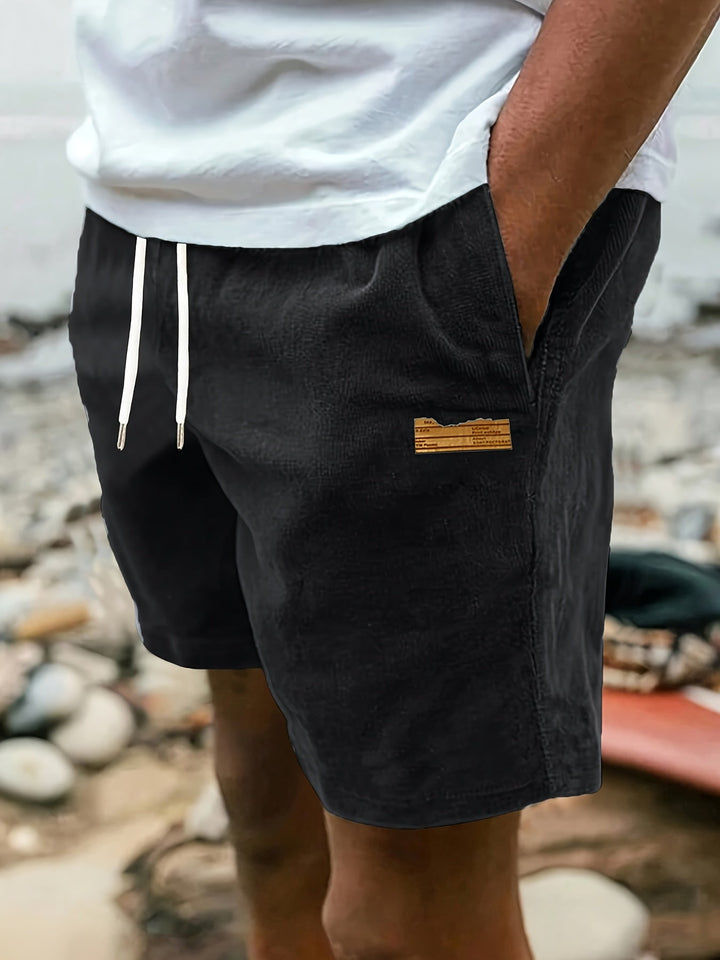 Men's black relaxed drawstring shorts worn outdoors