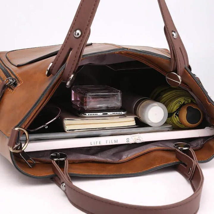 Grey women bag showing spacious interior compartments and sturdy gold-tone zippers