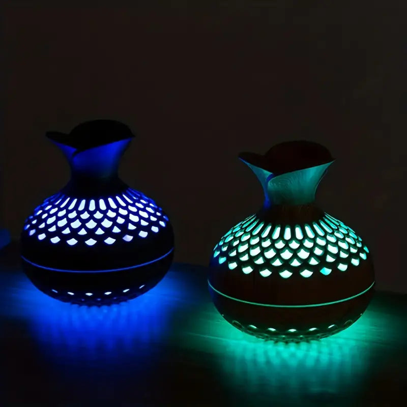Modern essential oil diffuser with LED night light on wooden surface