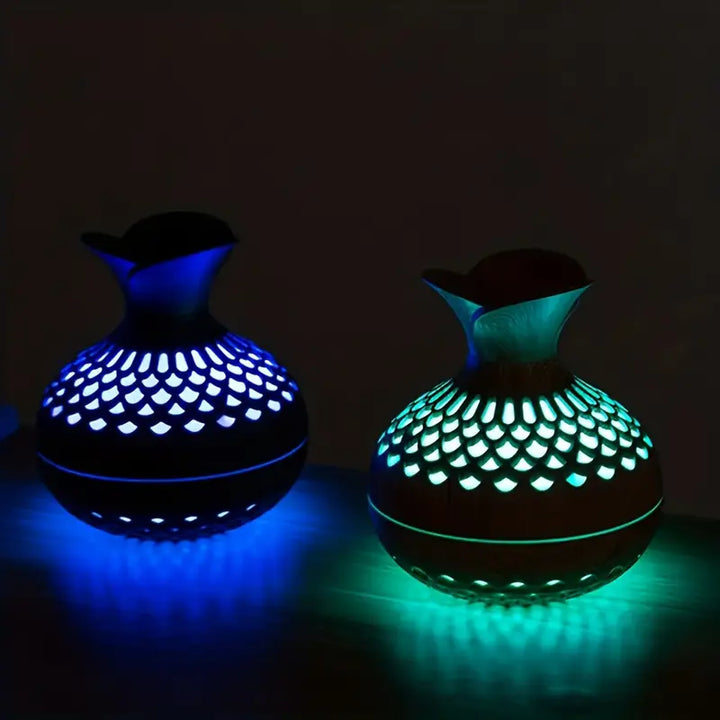 Modern essential oil diffuser with LED night light on wooden surface