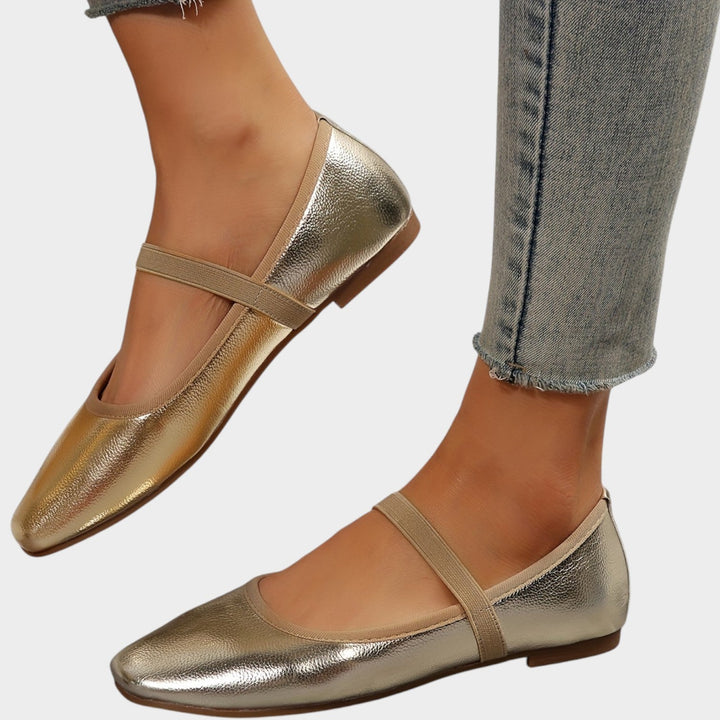 Side angle view of golden ballet flats with elastic strap detail