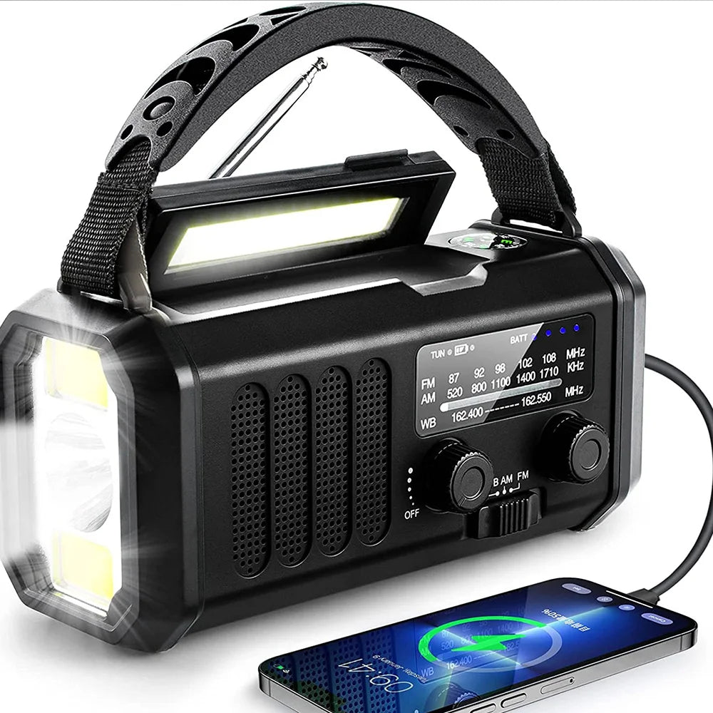 Black solar hand crank emergency radio charging a smartphone via USB cable