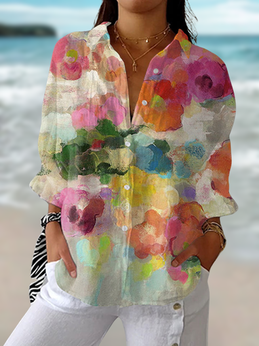 Woman wearing a multicolour watercolour print button-down blouse against a beach background