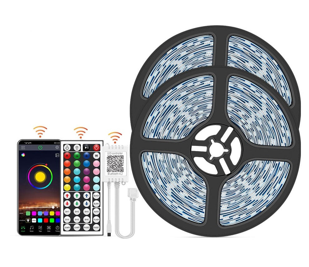Complete kit including LED strip reels, smartphone displaying app, remote control, and Bluetooth adapter
