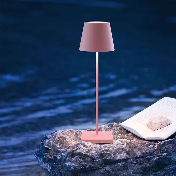 Rechargeable desk lamp casting warm LED lighting in a living room
