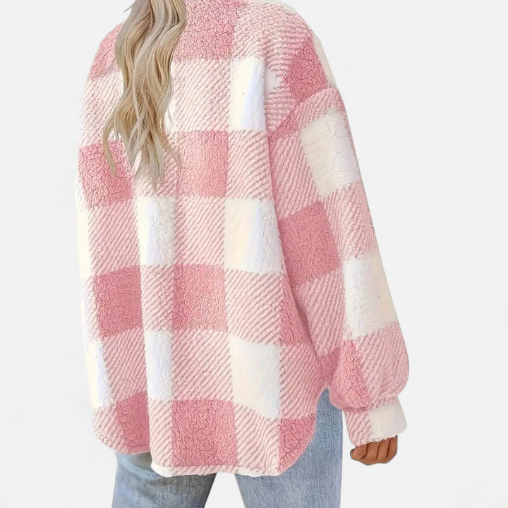 Detailed shot of chest pocket and button closure on women's casual plaid outerwear jacket
