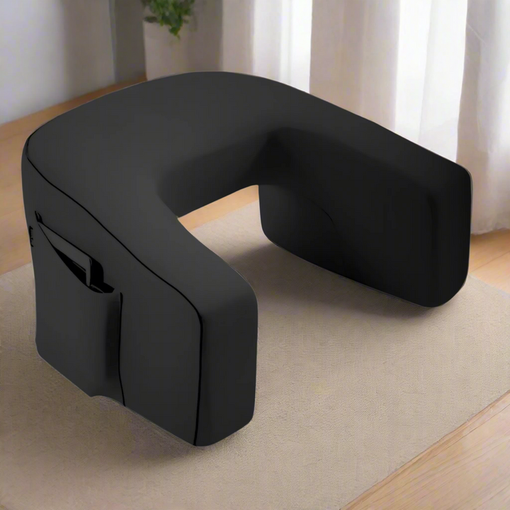 Gamer using the grey support cushion comfortably on a living room sofa