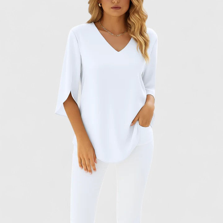 Woman wearing white V-neck split-sleeve summer blouse with white pants