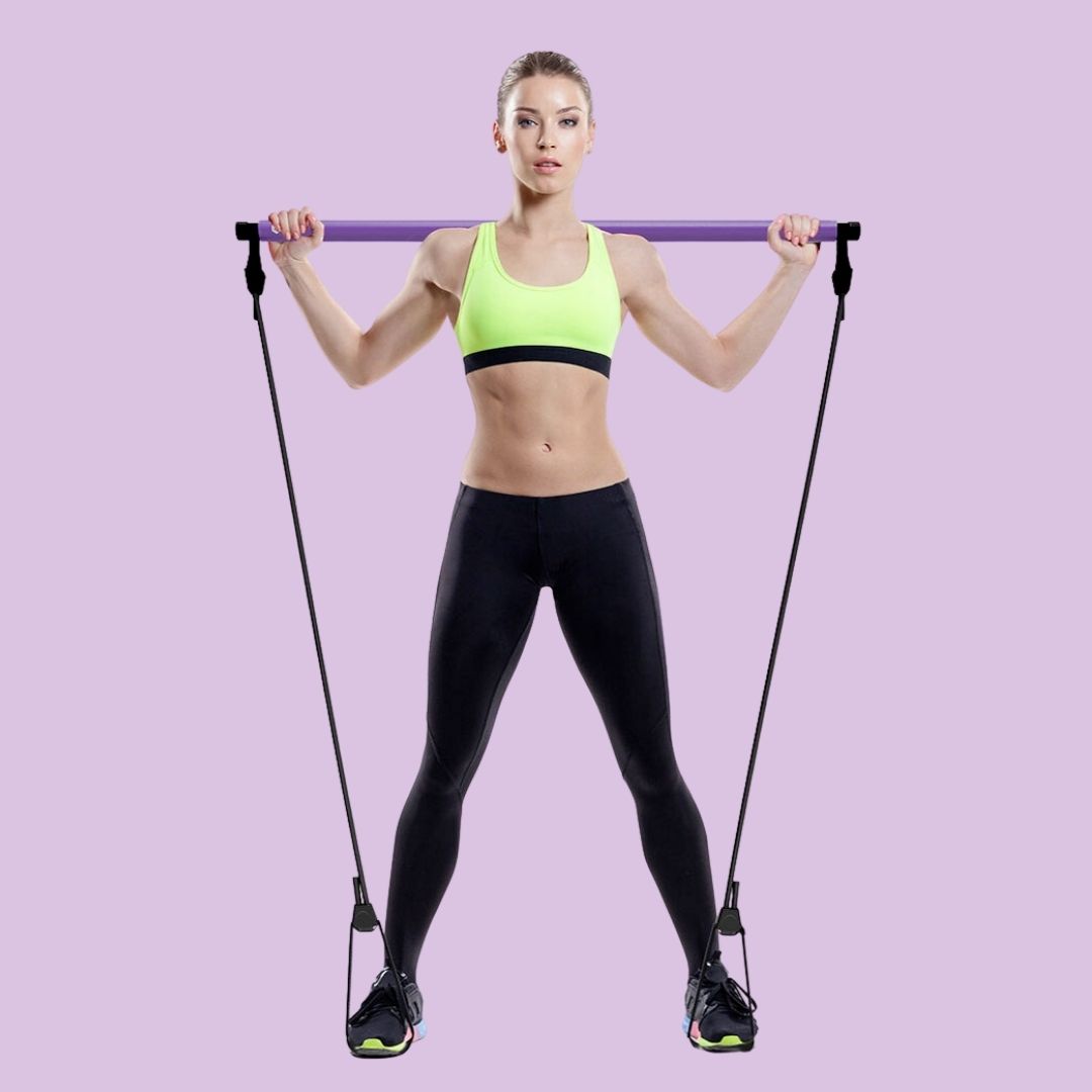 Woman holding the purple stretch pilates bar during a home workout