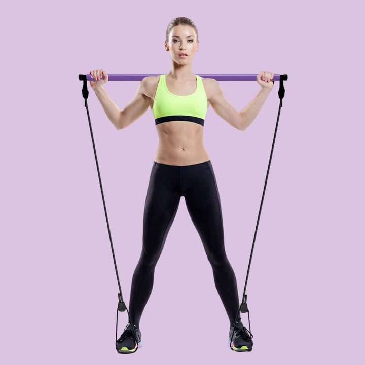 Woman holding the purple stretch pilates bar during a home workout