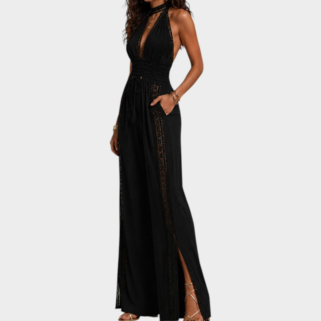 Side profile of a woman wearing a black sleeveless jumpsuit with ruched waist