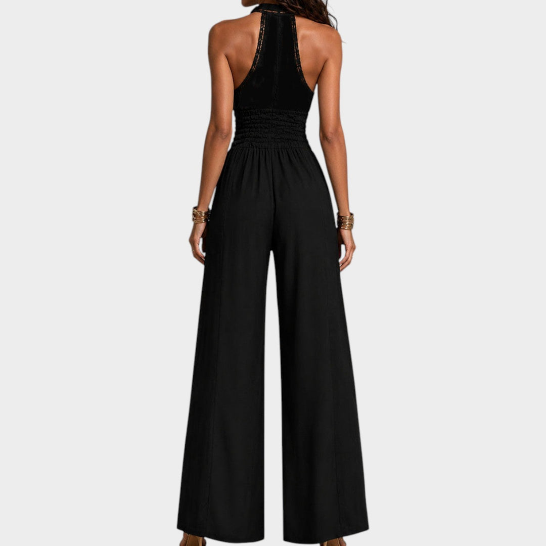 Back view of a woman wearing a black wide-leg jumpsuit with halter neck styling