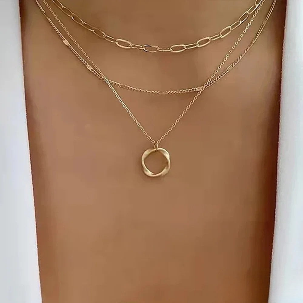 Women wearing a retro gold layered necklace with multiple strands and a circular pendant