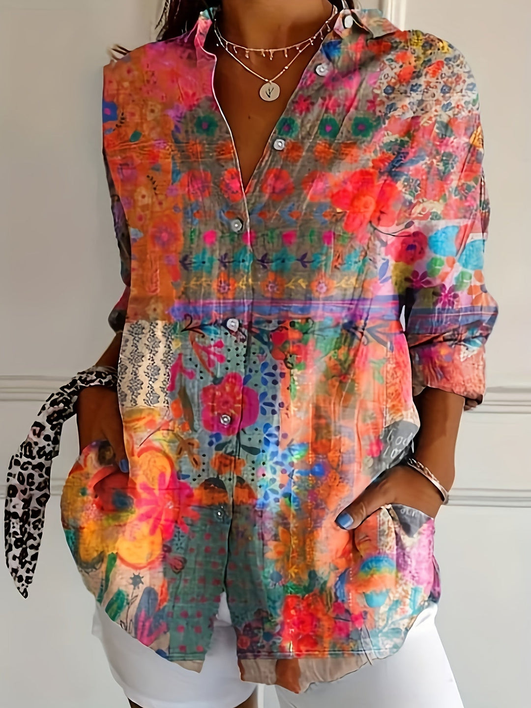 Woman wearing a vibrant floral collared long sleeve shirt in a casual setting