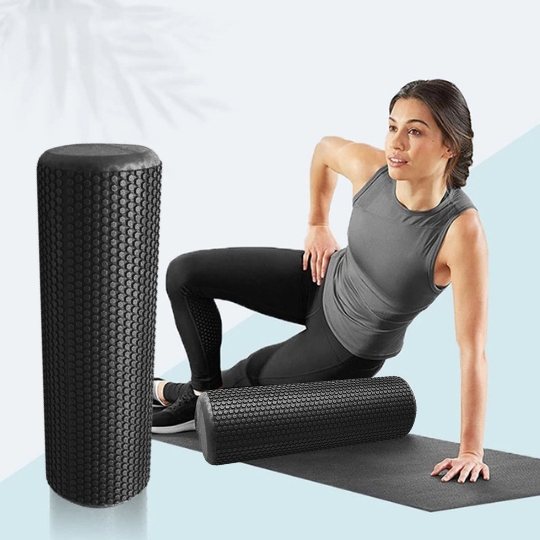 Woman exercising with a black round foam roller on a yoga mat