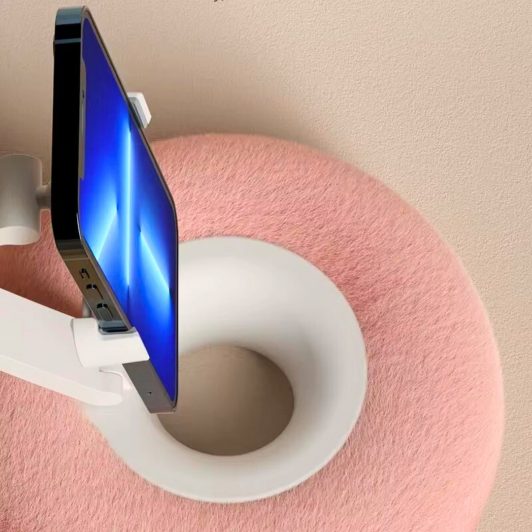 Beige hands free phone stand pillow resting on a cozy couch for easy streaming