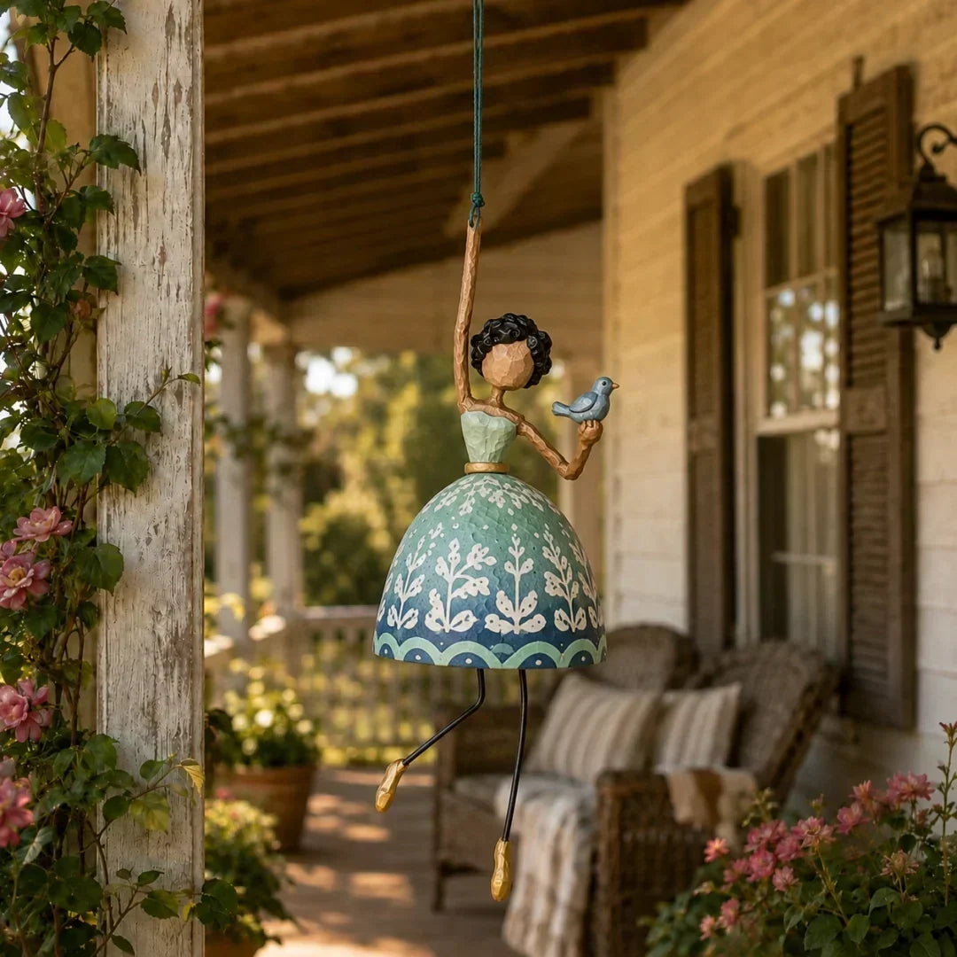Decorative garden spinner hanging from a tree branch outdoors