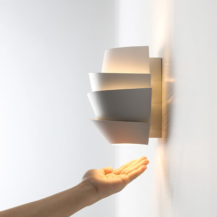 Side angle view of the modern white iron wall lamp showing its layered architectural design.
