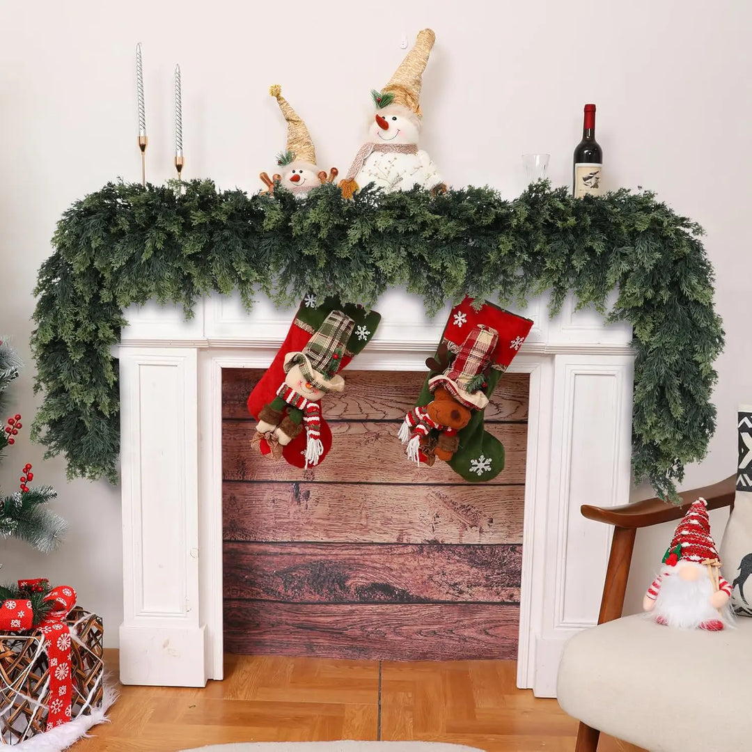 Artificial cedar garland displayed on a white fireplace mantel decorated for Christmas
