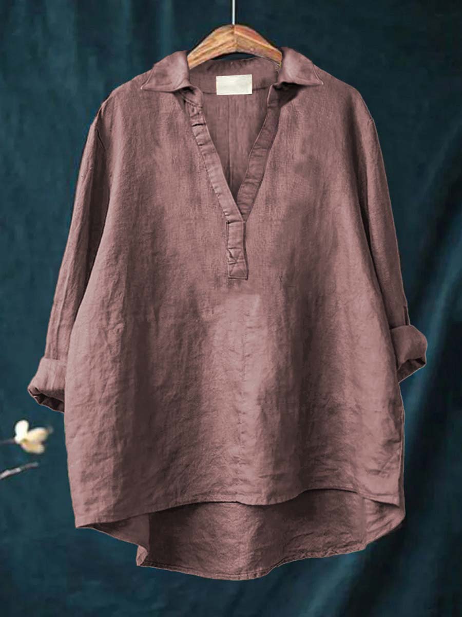 Burgundy women's long sleeve blouse hanging against dark background