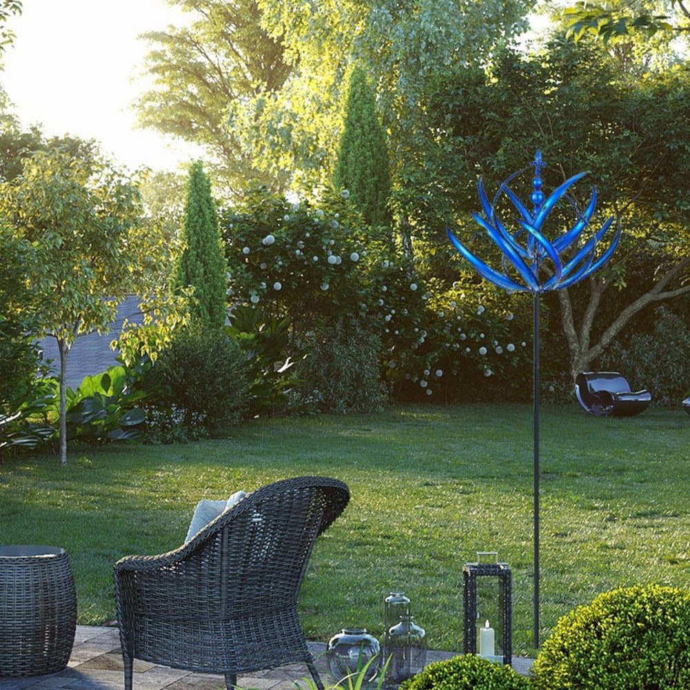 Close-up view of the blue kinetic wind spinner rotating on a green lawn