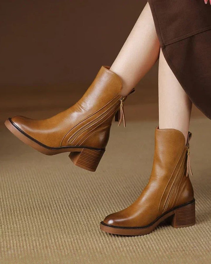 Pair of brown block heel boots styled with a skirt for an elegant outfit