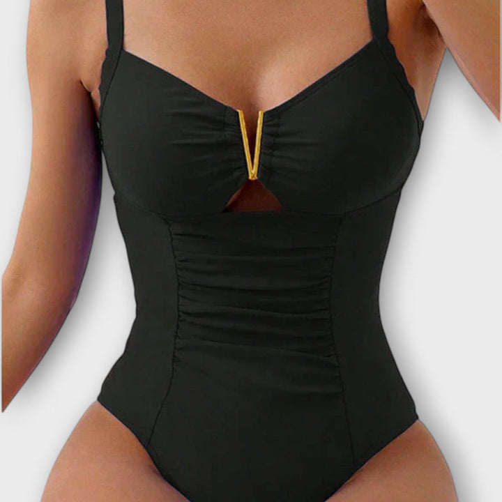 Close-up of a black one-piece swimsuit with metallic V-accent