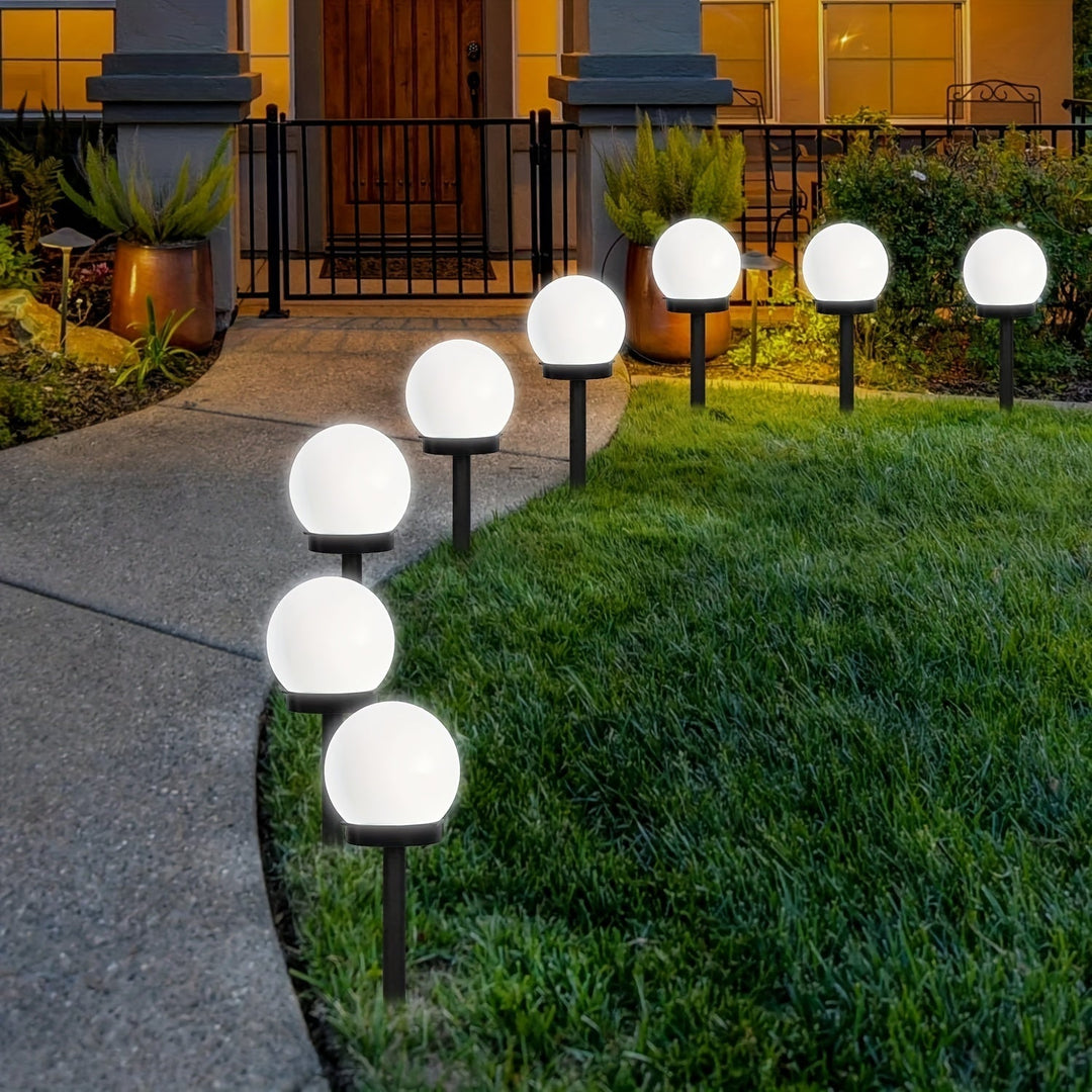 Weatherproof outdoor solar light casting a warm glow on stone pavers in a modern yard.