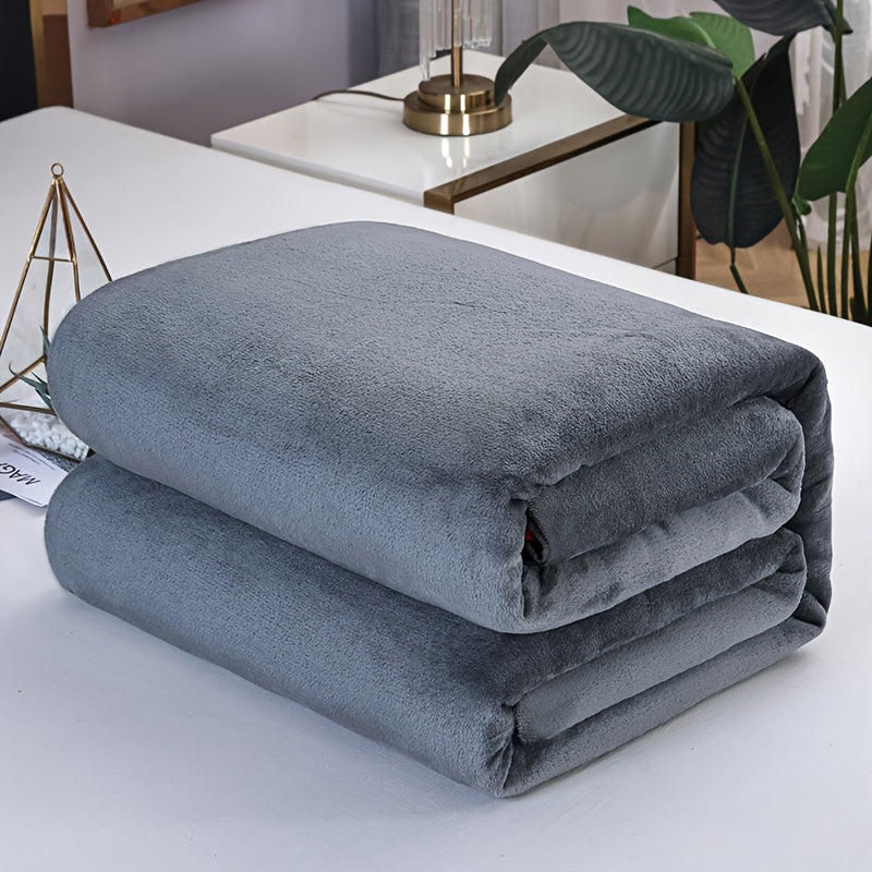 Folded dark grey flannel fleece blanket on a white table