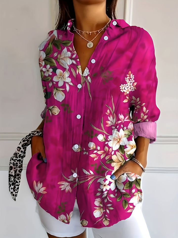 Woman wearing a vibrant pink floral collared long sleeve blouse with front pockets