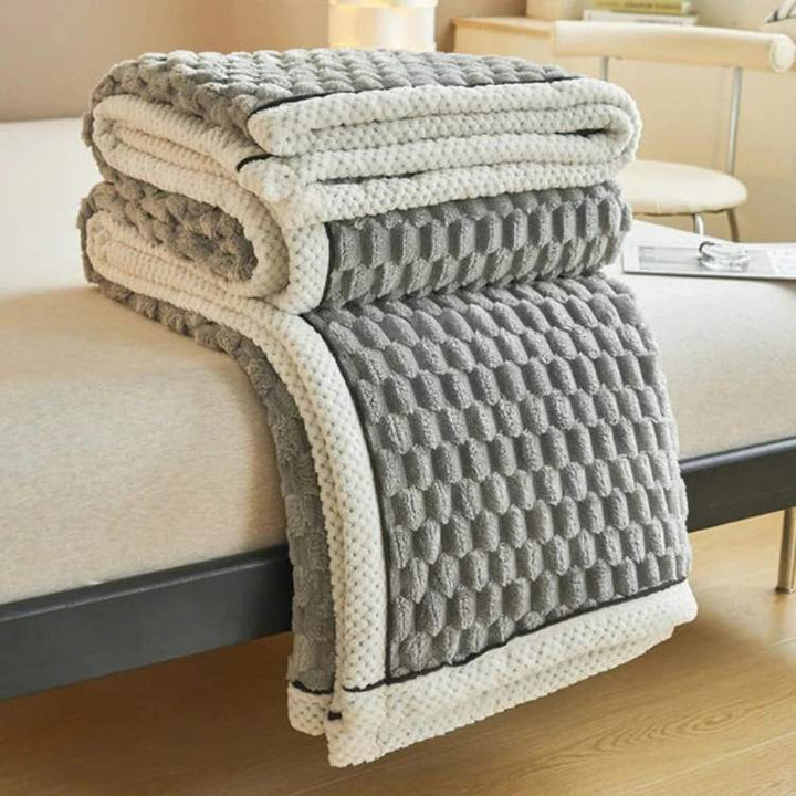 Lifestyle shot of reading in bed wrapped in a comforting sleep aid throw
